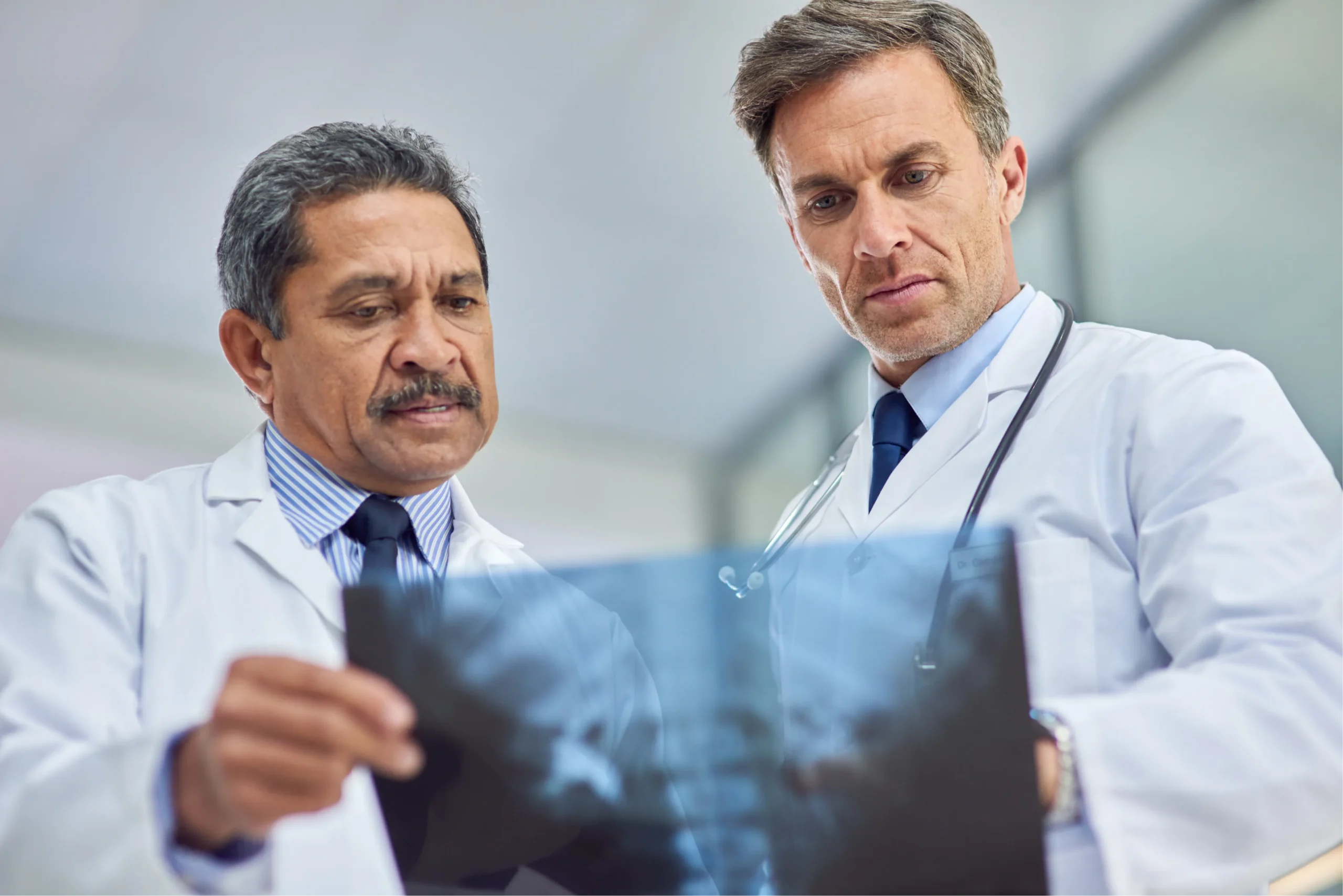 Orthopedic physicians reviewing diagnostic imaging and X-rays to evaluate a musculoskeletal condition.